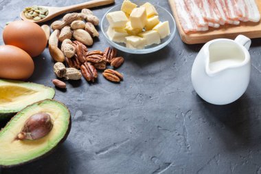 Keto ürün: avokado, tereyağı, pastırma, yumurta, siyah arka plan fındık. Sağlıklı yağlar kavramı