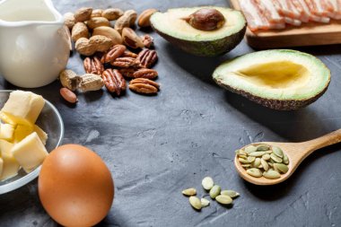Keto ürün: avokado, tereyağı, pastırma, yumurta, siyah arka plan fındık. Sağlıklı yağlar kavramı