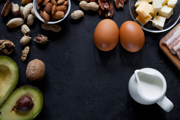 Ketogenic diet food: avocado, nuts, cream, oil, bacon, closeup