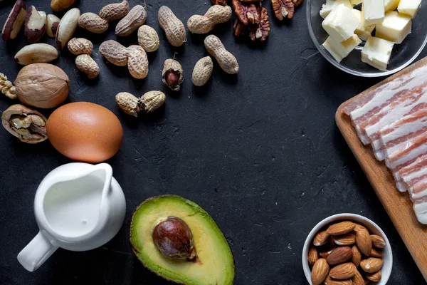 Ketogenic diet food: avocado, nuts, cream, oil, bacon, closeup