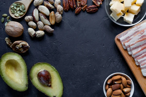 Ketogenic diet food: avocado, nuts, cream, oil, bacon, closeup