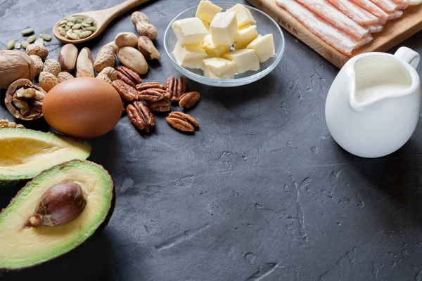 Ketogenic diet food: avocado, nuts, cream, oil, bacon, closeup