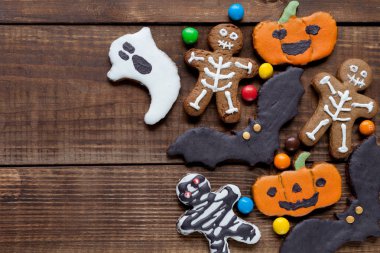 Ahşap zemin üzerinde kurabiyeler olan Cadılar Bayramı arka planı, üst görünüm.