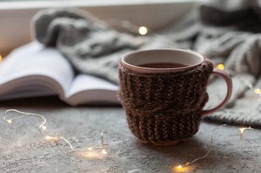 Pencere kenarında bir fincan sıcak çay, kızlık zarı konsepti, yakın plan.