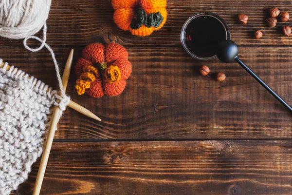 Koyu ahşap arka plan, örgü aksesuarlar ve bir fincan siyah çay..