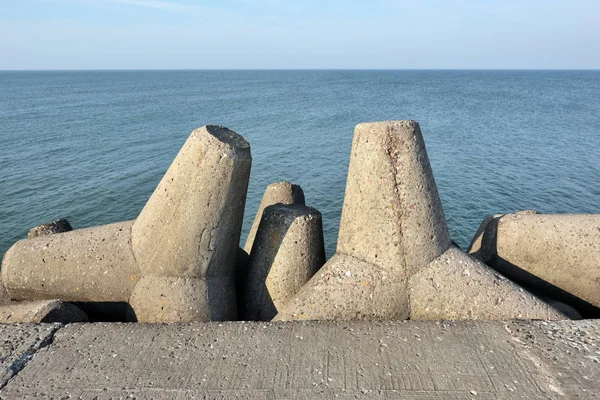 コンクリートの防波堤 海の嵐の波の破壊的な影響から海岸構造物を保護するためにコンクリートの Tetrapodes と海の風景 — ストック写真