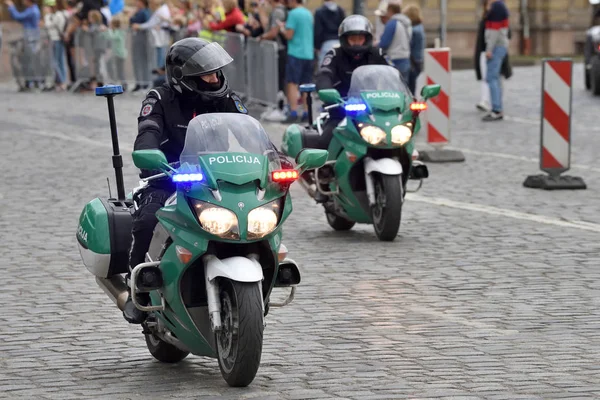 Полицейский едет на мотоцикле в Старом городе Вильнюса — стоковое фото
