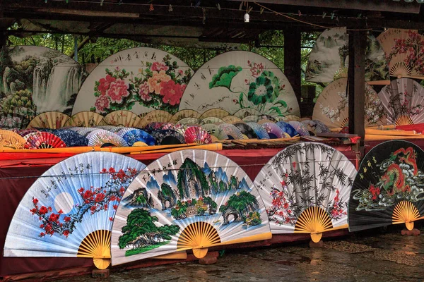 Traditionele ambachtelijke chinese ventilators withs imajing van landschap en bloemen op markt in Yangshuo, China. — Stockfoto