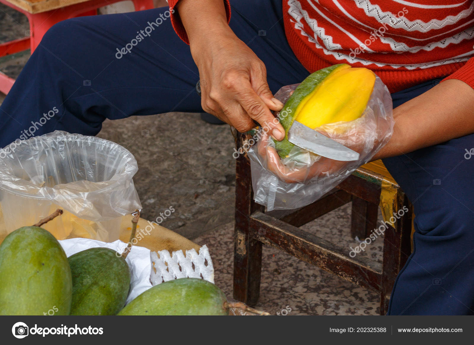 Peeling E Condivisione Il Mango Giallo Maturo Foto Stock