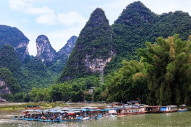 Karstik doruklarına Lijiang Nehri olarak bilinen Li Nehri üzerinde Xingping kasabanın ve zevk tekneler.