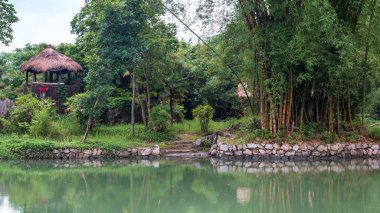 Yangshuo Shangri-la, Baishai, Çin azınlık köyde yanındaki ağaçlar arasında yürüyüş iz üzerinde bina otantik otantik Çin.