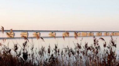 Sedanka düşük su köprü De Friz Yarımadası arasında Amur Bay Primorsky Krai Rusya'ya karşı bir kırmızı günbatımı gökyüzü arka plan için. Uzakdoğu peyzaj. Yatıştırıcı ülke sahne.