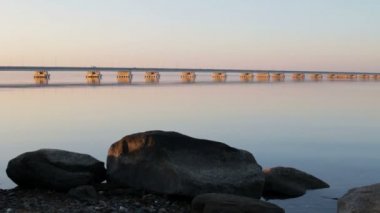 Sedanka düşük su köprü De Friz Yarımadası arasında Amur Bay Primorsky Krai Rusya'ya karşı bir kırmızı günbatımı gökyüzü arka plan için. Uzakdoğu peyzaj. Yatıştırıcı ülke sahne.