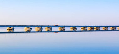 Sedanka düşük su köprü De Friz Yarımadası arasında Amur Bay Primorsky Krai Rusya'ya karşı bir kırmızı günbatımı gökyüzü arka plan için. Uzakdoğu peyzaj.