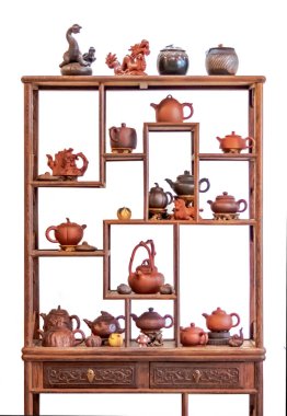 Wooden shelf and ceramic teapots, cups, and other attributes for a traditional tea ceremony. Isolated on white background.
