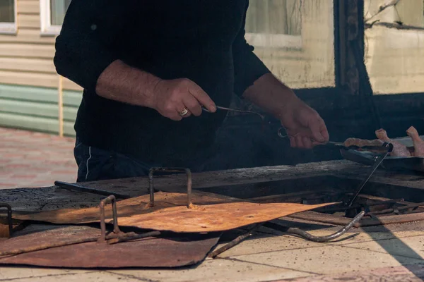 Кавказский барбекю шеф-повар готовит тандыр для приготовления куриного шашлыка в обычном городском месте, расслабляясь рядом с пляжем — стоковое фото