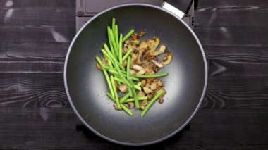 Sarımsak filizi ve tavuk fileto ile dilimlenmiş mantar parçaları soya sosu ekleyin bir wok tavada bir yağda kızartılmış. Ev yapımı tarife göre champignons ve kızarmış erişte ile pişirme. Yakın.