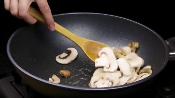 切碎的蘑菇片和鸡片在锅中的油中煎炸 家庭食谱中用香饼烹饪的过程的一部分 — 图库视频影像