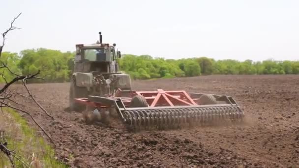 Трактор вспахивает почву . — стоковое видео