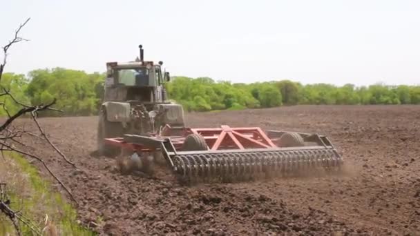 De trekker ploegen de bodem. — Stockvideo