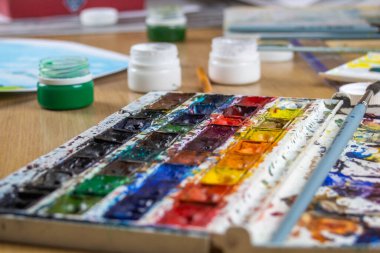 Resim çizmek için rengarenk sanat yağları ve guaj boyalarının paletini ayarla