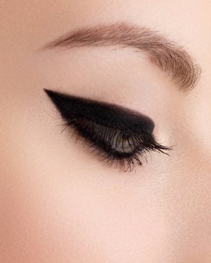 Kozmetik ve makyaj. Seksi siyah liner makyaj güzel kadın gözle. Moda büyük ok şekli kadının göz kapağı üzerinde. Şık akşam makyaj