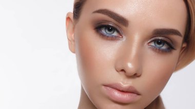 Güzel kadın modelinin göz kamaştırıcı portresi. Günlük makyajlı ve romantik dalgalı saç stili. Cilt üzerinde parlak parlak moda, seksi dudak parlatıcı makyaj ve koyu kaşlar.