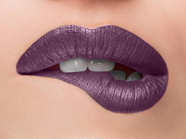 Yakın çekim güzellik portre modeli büyük seksi dudaklar, ağzı açık, beyaz dişler Bit alt dudağı baştan çıkarıcı dudaklar leylak. Makro görüntüsü mükemmel dolgun dudaklar. Güzel kadın dudak tutkuyla, beyaz dişlerini biraz