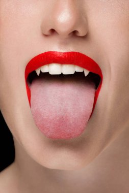 Seksi kadın dudakları kırmızı kırmızı ruj ile makro fotoğraf. Kadın dili ve bembeyaz dişleriyle dişleri bir vampir gibi gösterir. Diş Hekimliği, kozmetik, Cadılar Bayramı