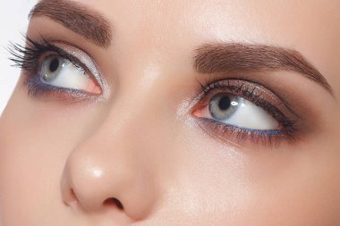 Trendy akşam makyaj, kalın Hatta kaşları ve uzun rustnitsami kadın gözlerle Close-up. Gri-mavi gözler, lensler, görme, kozmetik, makyaj