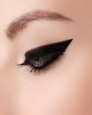 Kozmetik ve makyaj. Seksi siyah liner makyaj güzel kadın gözle. Moda büyük ok şekli kadının göz kapağı üzerinde. Şık akşam makyaj
