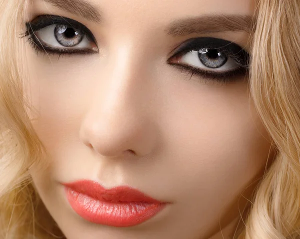 Şehvetli modeli kız onun yüzüne dokunmadan göz kırpıyor, manikür çivi, güzellik teen yüz beyaz arka plan üzerinde izole. Neşeli genç kadın parlak makyaj, kırmızı dudaklar ve çivi, makyaj sanatçısı, modeli yüz ile moda