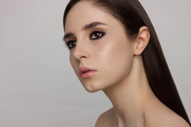 Güzellik ve kadın ile temiz parlak deri kahverengi gözleri ve saç üzerinde karanlık dumanlı gölgeler closeup. Son derece uzun kirpik ve ihale dudaklar, çilli. Moda, spa, kozmetik, makyaj, kozmetik