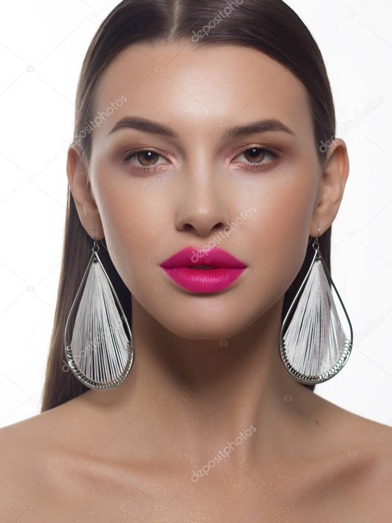 Close-up portrait of a beauty woman with straight hair and perfectly clean skin. Daytime makeup, styling and elegant decoration on the ears - earrings. Skin care in the spa salon or cosmetology