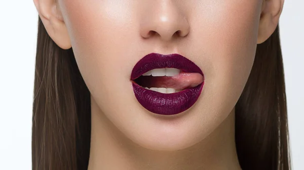 Nahaufnahme von sexy weiblichen Lippen mit Zunge. Saubere Haut und eine klare Lippenkontur werden mit einem modischen Marsala-Lippenstift umrissen. Weiße Zähne und die Schönheit des Lächelns für stamotologii, Wellness oder Kosmetologie — Stockfoto