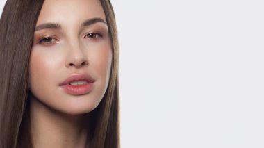 Closeup düz saç geliştirme ile bir kadın portresi. Tatlı ihale genç kız esmer. Doğal rujlar, şeffaf temiz cilt. Spa salonu veya Kozmetik Cilt Bakımı doğal kozmetik.