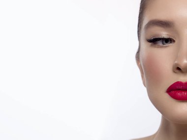 Close-up beauty of a half female face with creative fashion evening make-up. Black arrows on the eyes and extremely long eyelashes, on plump lips matte pink lip color. Well-groomed skin after spa