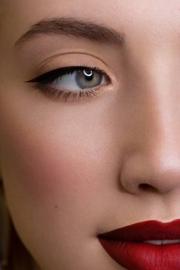 Güzel bir akşam makyajıyla yarım bir güzellik portresi, gözlerde siyah titreşimler ve son derece uzun kirpiklerle. Dudaklarında pembe ruj izi var. Kozmetik ve kaplıca cilt bakımı