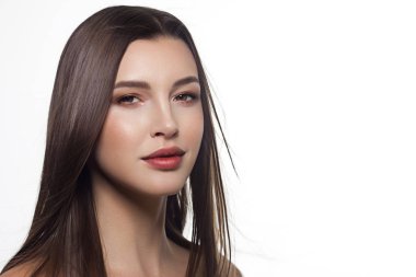 Closeup düz saç geliştirme ile bir kadın portresi. Tatlı ihale genç kız esmer. Doğal rujlar, şeffaf temiz cilt. Spa salonu veya Kozmetik Cilt Bakımı doğal kozmetik.