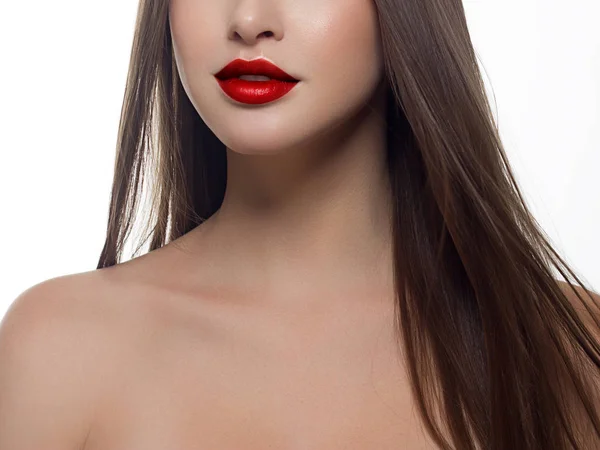 Cosméticos, maquillaje y tendencias. Brillo labial brillante y lápiz labial en los labios. Primer plano de hermosa boca femenina con maquillaje de labio rojo. Hermosa parte de la cara femenina. Piel limpia perfecta en luz roja —  Fotos de Stock