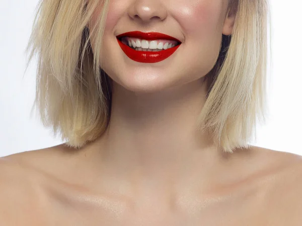 Primo piano sorriso femminile felice con denti bianchi sani, trucco rosso brillante labbra lucide. Cosmetologia, odontoiatria e bellezza. Macro della bocca sorridente della donna — Foto Stock