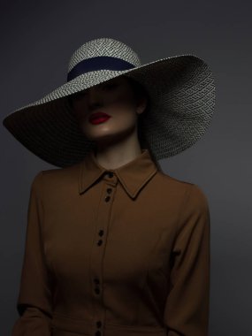 Dudaklarında kırmızı ruj ve büyük bir şapka ile güzel kadın portre. Gizemli bir kızın vintage görüntüsü. Modaya uygun makyaj. Şapka yüzün yarısını kaplıyor. Siyah eyeliner ve son derece uzun kirpikler