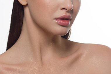 Kozmetik, makyaj ve trendler. Parlak dudak parlatıcısı ve ruj. Doğal dudak makyajlı güzel bir kadın ağzı. Kadın yüzünün güzel bir parçası. Doğal ışıkta kusursuz temiz bir ten.