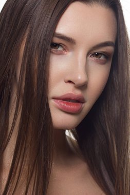 Closeup düz saç geliştirme ile bir kadın portresi. Tatlı ihale genç kız esmer. Doğal rujlar, şeffaf temiz cilt. Spa salonu veya Kozmetik Cilt Bakımı doğal kozmetik.