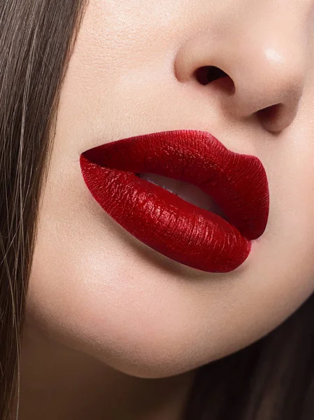 Macro photo of plump lips with bright red matte lipstick. Clean skin, lip injections. Evening fashion makeup closed mouth — ストック写真