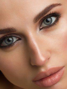 Parlak makyajlı, seksi kırmızı çizgili güzel bir kadın. Kadının göz kapağında büyük bir ok şekli var. Doğal dudaklar. Şık bir akşam makyajı. Lüks uzun dalga saçı. Parlak yüz derisi