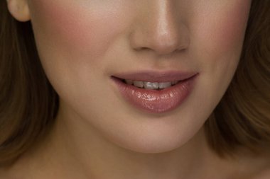 Gülümseyen genç kız. Güzellik suratı yakın plan. Seksi dudaklar. Güzellik doğal dudak makyajı ayrıntıları. Çok güzel bir yakın çekim. Dişleri olan şehvetli bir ağız. Ruj ve ruj.