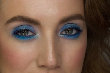 Aşırı uzun kirpikli ve dumanlı makyajlı dişi yeşil gözlü güzel bir makro çekim. Mükemmel kaşlar ve uzun kirpiklerle. Makyaj malzemeleri ve makyaj malzemeleri. Moda bakışlarının yakın çekim makro çekimi.