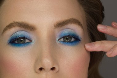 Aşırı uzun kirpikli ve dumanlı makyajlı dişi yeşil gözlü güzel bir makro çekim. Mükemmel kaşlar ve uzun kirpiklerle. Makyaj malzemeleri ve makyaj malzemeleri. Moda bakışlarının yakın çekim makro çekimi.
