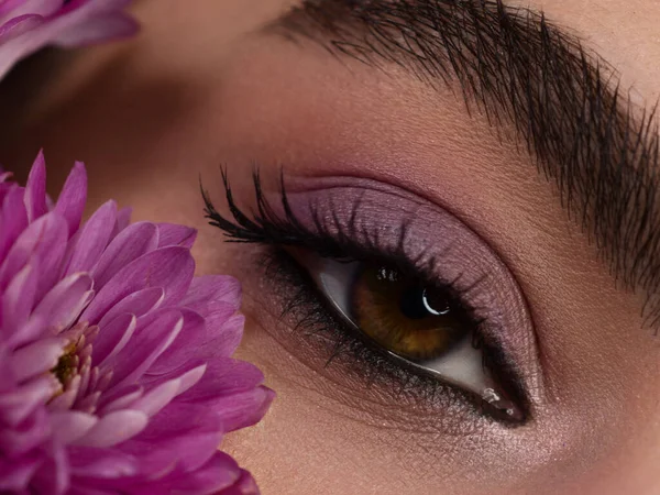 Macro shot of woman\'s beautiful eye with extremely long eyelashes. Sexy view, sensual look. Female eye with long eyelashes